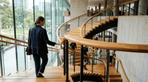 Close-up of a hand gripping a securely mounted aluminum stair handrail alongside outdoor steps